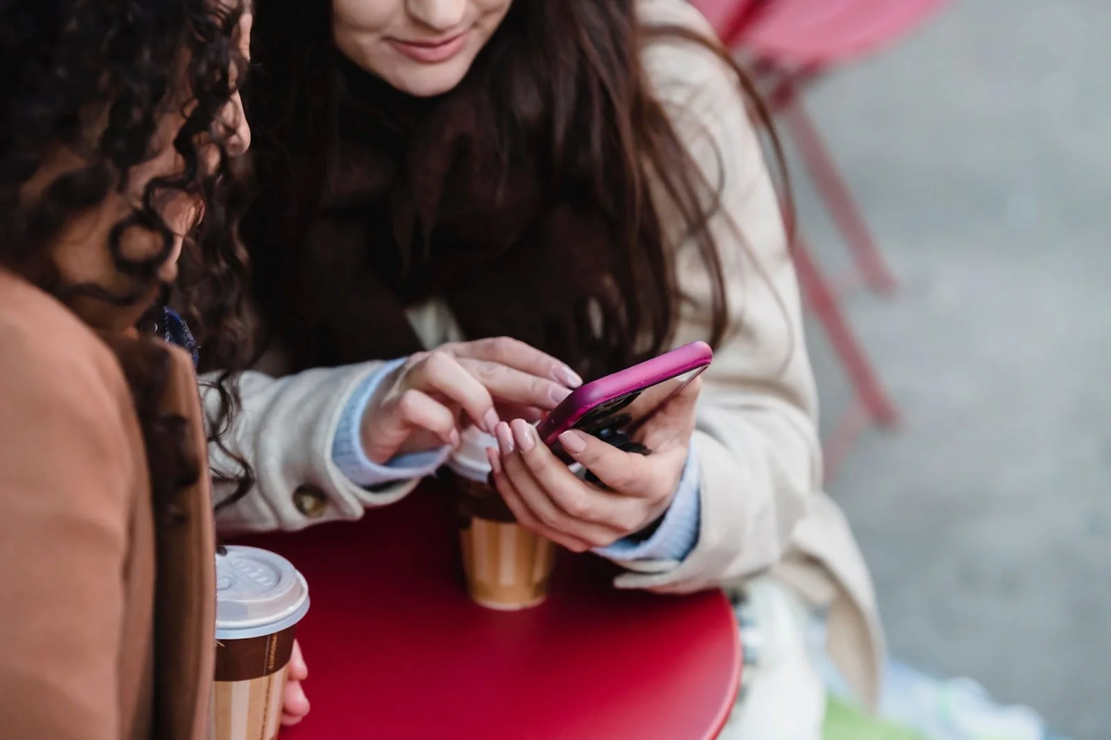 2 femmes à tables sur leur téléphone