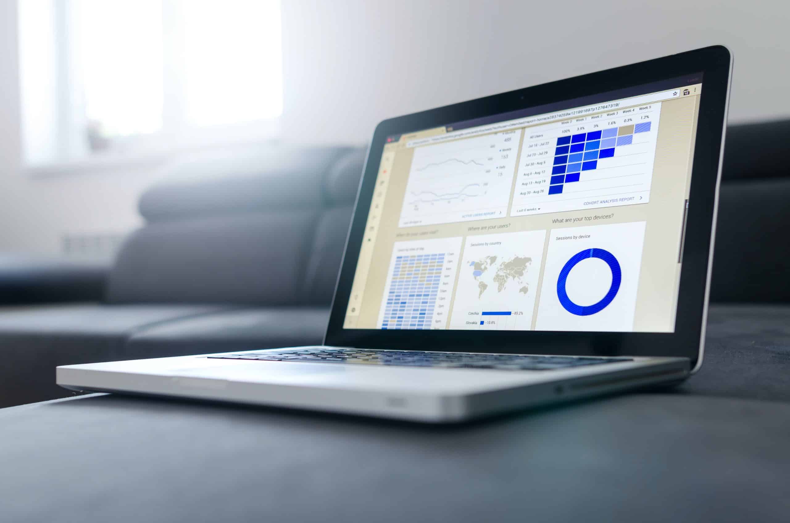 Ordinateur allumé et posé sur un canapé et affichant une page web comprenant des statistiques